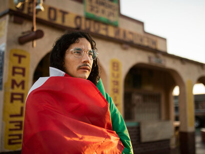 Un hombre rodeado con la bandera de México