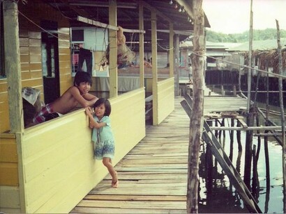Bambini che vivono nelle case sull'acqua del fiume Brunei