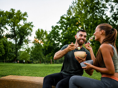 Athletic couple enjoying a healthy post-workout meal together after a demanding fitness session