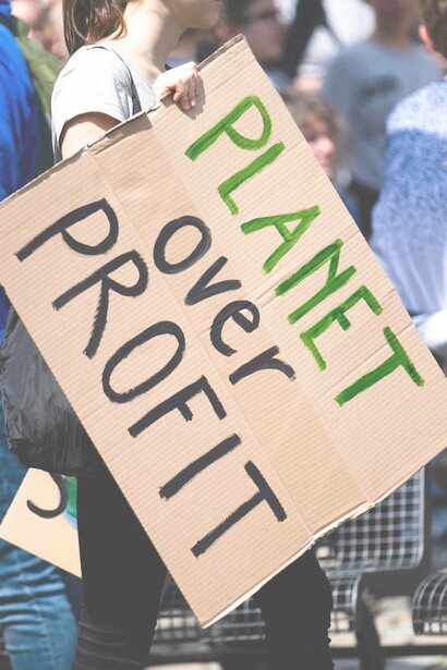 A sign that says 'planet over profit'