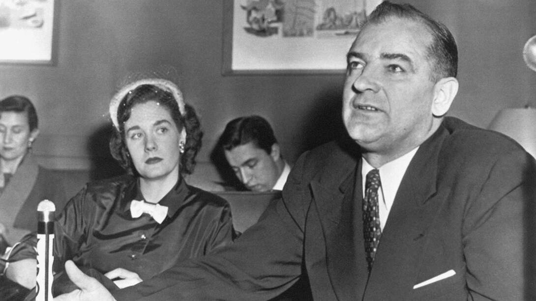 Im Februar 1950 hielt Senator Joseph McCarthy (1908–1957) eine Rede, in der er darauf hinwies, dass er über eine Liste mit Namen kommunistischer Funktionäre verfüge, die den US-Auswärtigen Dienst infiltriert hätten und in Botschaften oder als Analysten im Außenministerium tätig seien. Bild: Joseph McCarthy bei einer Pressekonferenz im Jahr 1954. Links seine Frau Jean McCarthy