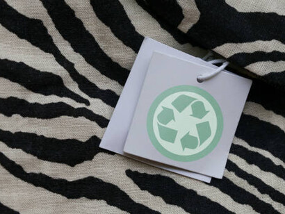 A clothing tag featuring a recycling icon, highlighting the concept of recycling products