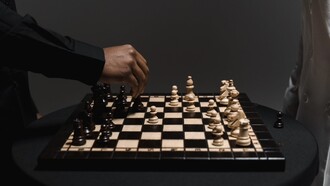 Dettaglio di una mano che valuta la prossima mossa sulla scacchiera