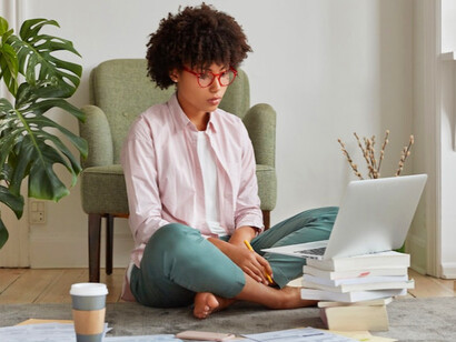 Sitting on the floor with her laptop, she’s creating a productive workspace that suits her unique needs in the new world of hybrid work