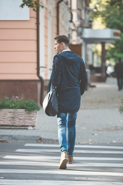 Young man on an evening stroll, crossing the street in a peaceful neighborhood