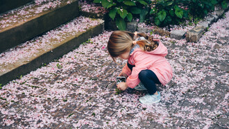 Bambina al parco con un cellulare in mano