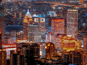 Towering skyscrapers lit against the night sky, reflecting humanity's technological progress and the responsibility to ensure it benefits everyone