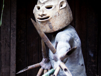 An Asaro Mudman enacts a scene of tribal lore, his masks capturing the essence of ancestral wisdom