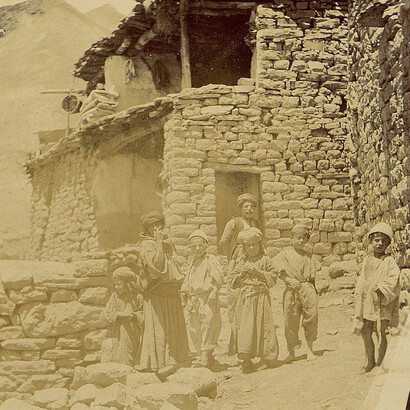 Assyrian family in front of a traditional Hakkari stone house, Türkiye, c. 1900