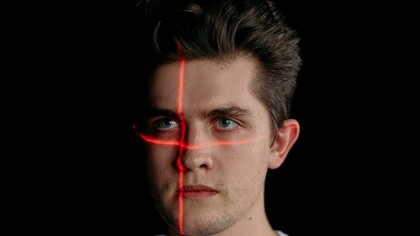 Portrait of a man with laser lines on his face, symbolizing facial recognition technology