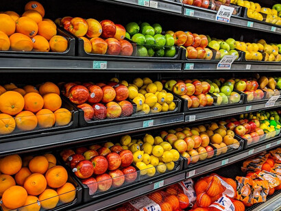 Yellow and red apples are neatly arranged on a black plastic crate, creating an appealing fruit display in a supermarket grocery store in Stillwater, OK, USA