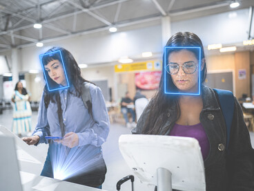 Professional travelers uses smartphone facial recognition during the airport check-in and security process
