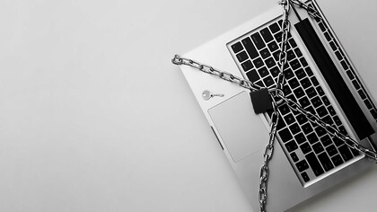 Secure your digital fortress with a top view of a laptop shielded by a metal chain and lock, highlighting GDPR compliance amidst the ChatGPT controversy and concerns over data protection authority and privacy breaches