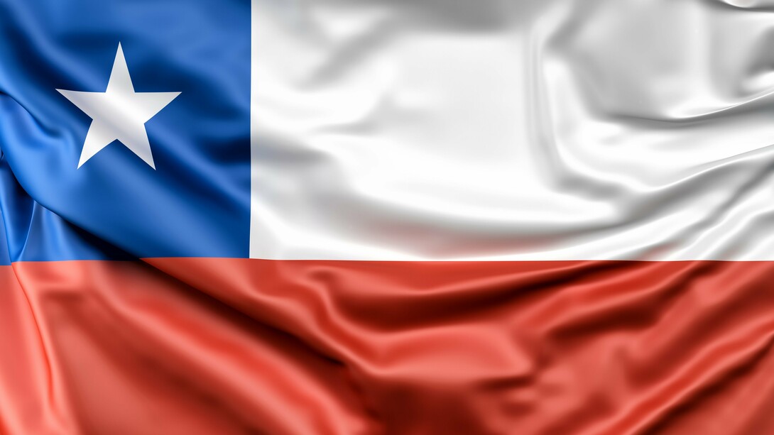 The Chilean flag, with its bold blue square and white star symbolizing the sky and honor, alongside red and white representing the nation's independence and courage, waves in anticipation of the pivotal 2025 presidential election