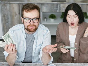 A man and woman reviewing their household budget, capturing the emotional strain of financial anxiety and economic stress