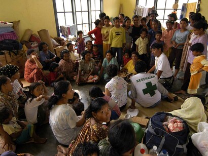 Representatives from the United Nations (UN) and the World Health Organization (WHO) converse with Indonesian nationals living at a camp located in the town of Alue Bilie, Aceh
