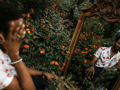 An isolated young man confronting his reflection in the mirror, revealing the loneliness, inner conflict, and identity crisis shaped by self-concealment