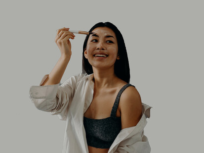 Mulher passa produto de pele no rosto