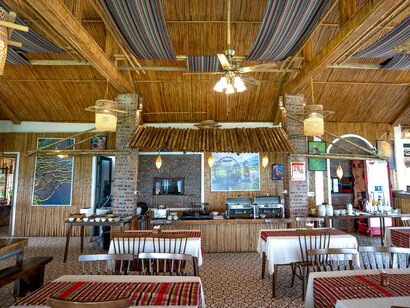 The walls and ceiling are covered in bamboo, and there are exposed brick columns and a brick cooking area in the center