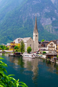 Scenic white and brown concrete building nestled near a serene body of water in Hallstatt, Austria, offering an idyllic outdoor retreat amidst nature