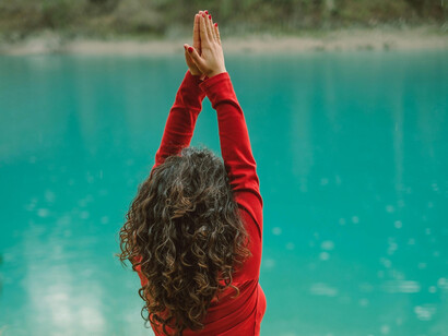 Aluna de yoga toca as mãos no alto de sua cabeça enquanto eleva seus batimentos cardíacos 