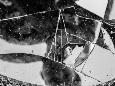 The reflection of a man scattered across shattered glass, reflecting a distorted relationship with truth, reality, and accountability