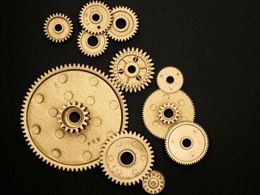 Detalhe de engrenagens evidencia o funcionamento integrado de mecanismos de alta precisão. Assim como em uma máquina, cada etapa do processo científico contribui para transformar descobertas em soluções capazes de gerar valor para a sociedade