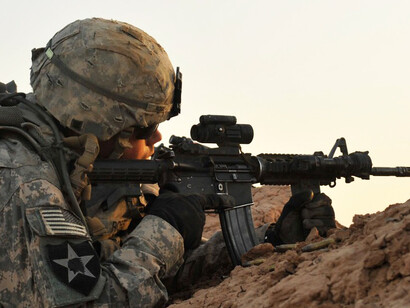 A U.S. soldier from Bravo Company, 5/20 Infantry, 2nd Infantry Division, provides supporting fire during a squad live-fire exercise at Kirkush Military Training Base in Diyala Province, Iraq, on June 10, 2010. U.S. and Iraqi forces trained to clear mined and wired obstacles, clear bunker complexes, and respond to enemy contact