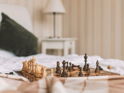 Tablero de ajedrez sobre una cama solitaria