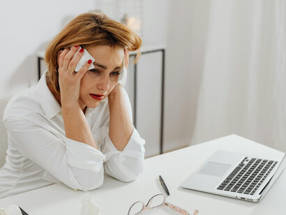 At work, a woman in white long sleeves breaks down in tears from stress