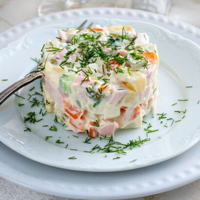 Ensalada de gallina con manzana, adornada con ramitas de eneldo