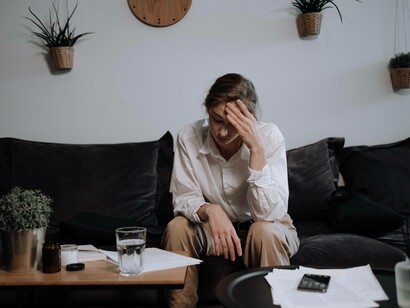 A woman placing her hand on her forehead to indicate she might require paracetamol