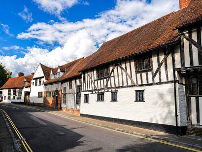 Lavenham, a historic village in Suffolk, England, is celebrated for its medieval Guildhall, Little Hall, magnificent 15th-century church, half-timbered cottages, and charming circular walks. In the medieval era, it was one of the twenty wealthiest settlements in England