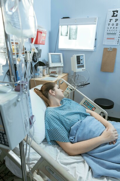 A sick woman lying in a hospital bed