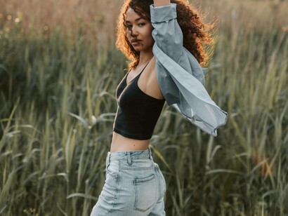 A woman with arms raised and dancing in a field to show how liberated she feels