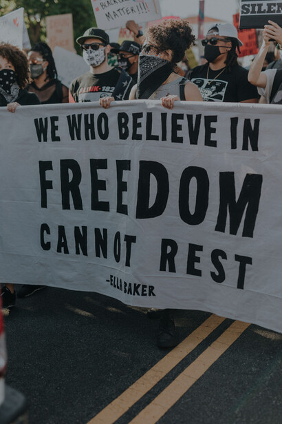 Varias personas llevan juntas una pancarta en defensa de la libertad