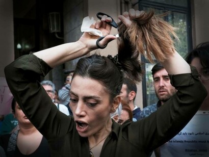 A woman cuts her hair to support Iranian women protesting the Regime of their country