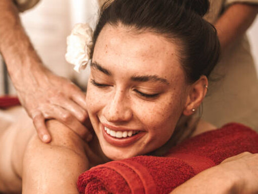 Alternative medicine: A woman smiles and laughs as a therapist performs a relaxing Ayurvedic massage
