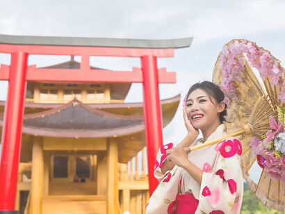 Gorgeous Asian woman dons a Japanese kimono, striking a pose in front of the iconic Torii gate at Tatsuta Shrine, Japan, embodying the timeless allure of traditional Japanese culture