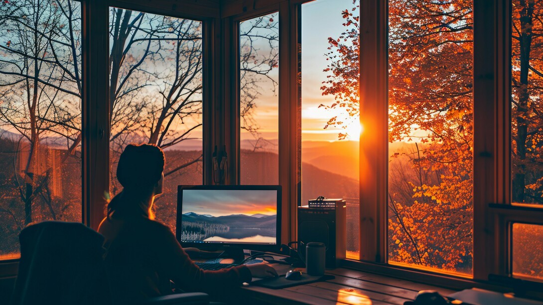 A founder at work overlooking the beauty of nature, reflecting the harmony between focused productivity and the natural world