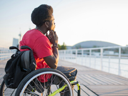 A man with Afro hair in a wheelchair, embodying resilience through personal transformation, self-discovery, cognitive growth, and healing