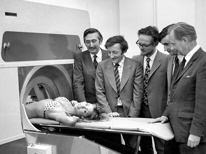 Demostración del EMI Scanner con el equipo formado por Godfrey Hounsfield (inventor), Tony Williams (diseñador mecánico), Peter Langstone (experto en electrónica), Steve Bates (programador informático), Chris Lemay (matemático que desarrolló la técnica para el ordenador) y la modelo Gillian Duxbury