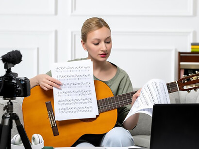 Experience the convenience of remote learning as a young, cute, and beautiful girl provides guitar classes from home, exemplifying the accessibility and charm of e-learning