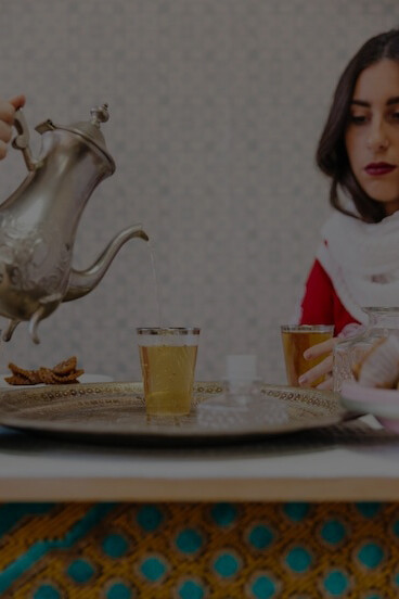 Iranian women enjoying tea and baklava, embodying traditions of Iranian cuisine