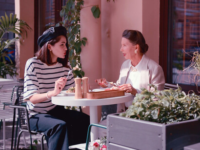 In the gentle morning light, breakfast with a friend at a French-style bistro becomes a delightful escape from the world's troubles, celebrating the enduring art of good food and companionship