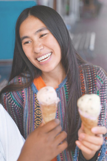 Central American woman delighting in a refreshing ice cream, showcasing vibrant regional culture and a joyful moment