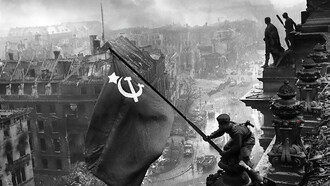 The legacy of WWII: Soviet soldiers raise the USSR flag over the Reichstag in Berlin at the end of the Second World War in 1945. The photograph is attributed to Soviet war photographer Viktor Temin
