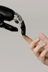 A human and a robotic hand barely touching, alluding to the Renaissance painting "The Creation of Adam", by Michelangelo Buonarroti