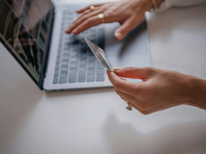 A woman entering her card details on a laptop, illustrating how loneliness drives online shopping and consumer spending as a way to seek comfort and connection
