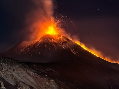 Vulcão Etna em erupção. A palavra Etna vem do grego “Eu queimo”.  Com uma área de extensão de mais de 1100 km e 3223 de altura aproximadamente, o vulcão está em constante atividade vulcânica